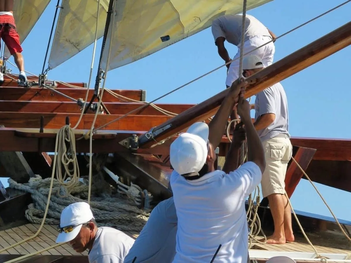 Crew working the sails aboard a traditional Indonesian schooner